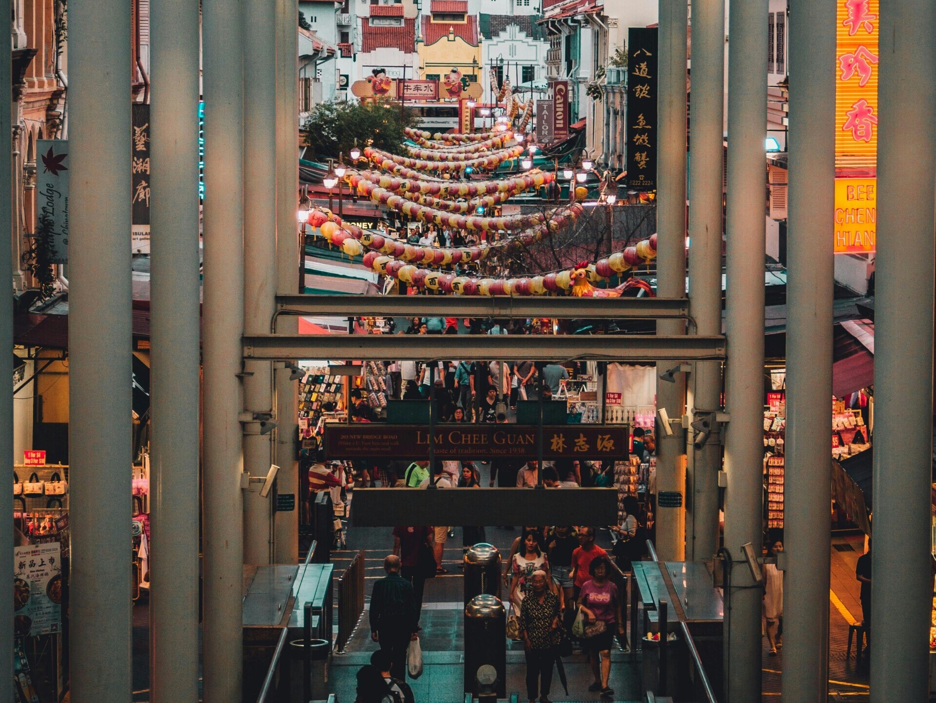 people gathered on the streets surrounded by stalls and buildings